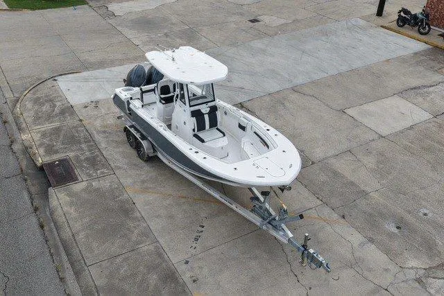 The Image of 2026 Tidewater 256 CC Adventure boat on trailer, parked on concrete surface. - 0