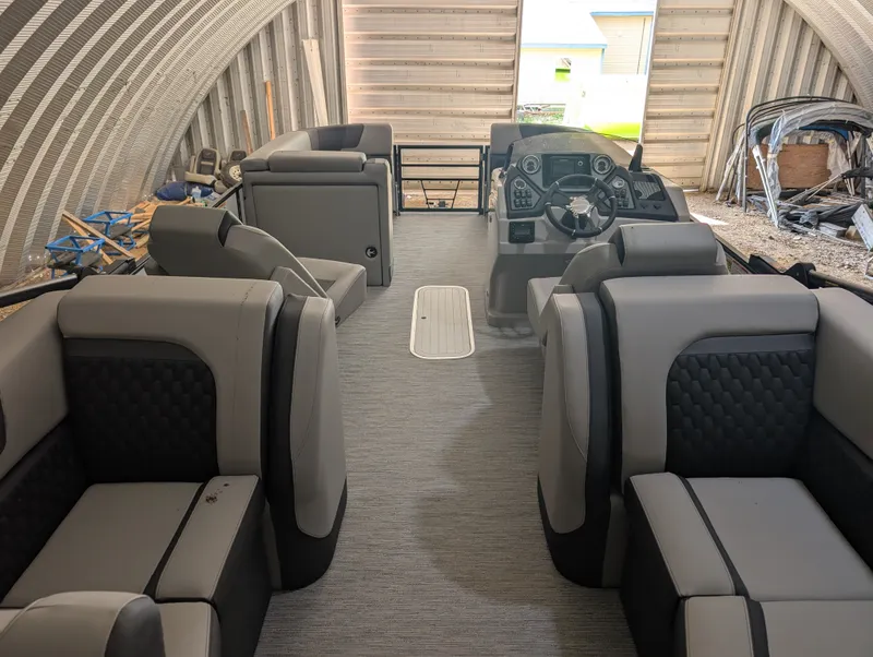 Slide: The Image of Interior of a 2026 Sylvan L3 LZ DH with gray and black seating in a warehouse. - 20