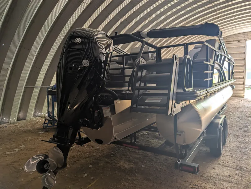 Slide: The Image of A 2026 Sylvan L3 LZ DH pontoon boat is on a trailer in a covered area. - 6