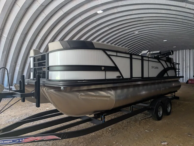 Slide: The Image of Sylvan L3 LZ DH 2026 pontoon boat in a covered storage area. - 2