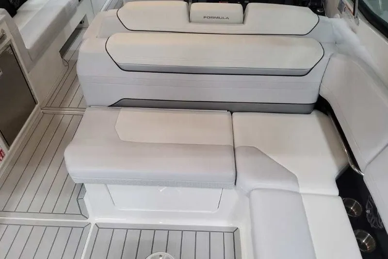 Slide: The Image of Die Innenansicht zeigt weiße Polsterbänke und einen grauen Bodenbelag auf einem Boot. - 27
