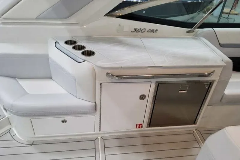 Slide: The Image of Die Innenansicht zeigt eine elegante weiße Sitzbank und eine kleine Küchenzeile mit Kühlschrank. - 29
