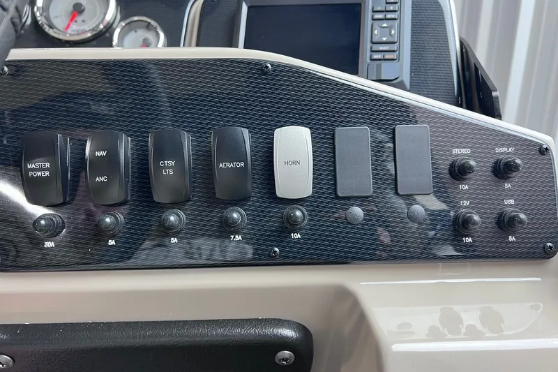 Slide: The Image of Control panel of 2026 SunCatcher Select 18F boat with switches and gauges. - 14