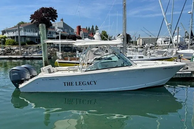 The Image of 2022 Cobia 280 Dual Console boat named "The Legacy" docked in a marina. - 0