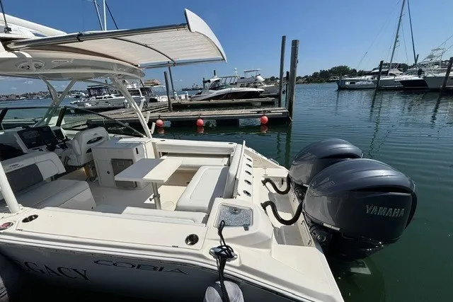 Slide: The Image of 2022 Cobia 280 Dual Console boat docked with twin Yamaha engines. - 17