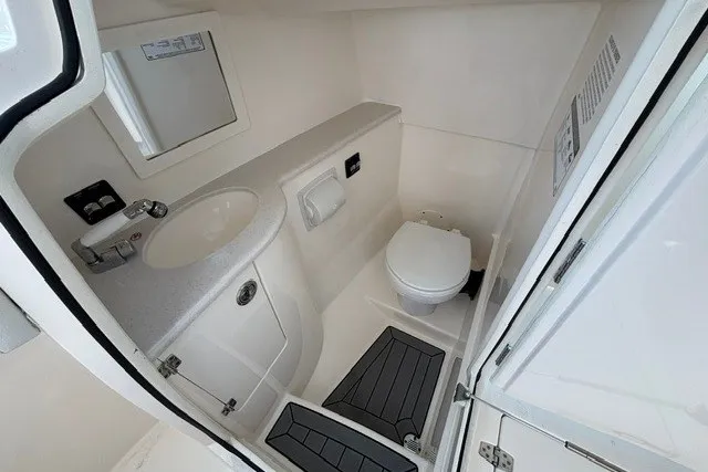 Slide: The Image of 2022 Cobia 280 Dual Console boat bathroom with sink, toilet, and storage. - 24