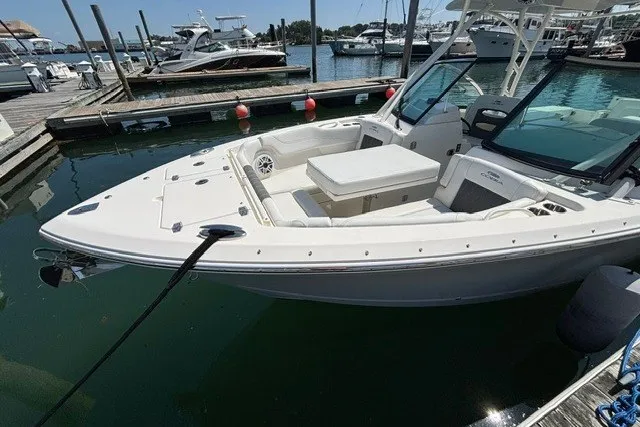 Slide: The Image of 2022 Cobia 280 Dual Console boat docked at a marina, showcasing sleek design and spacious seating. - 5