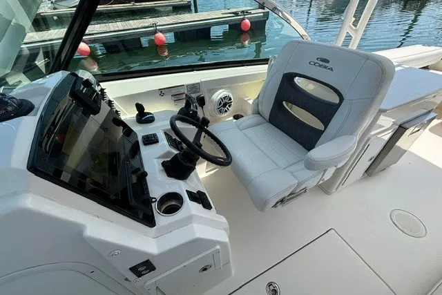 Slide: The Image of 2022 Cobia 280 Dual Console boat interior with steering wheel and captain's chair. - 8