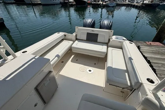 Slide: The Image of 2022 Cobia 280 Dual Console boat interior with seating, docked at marina. - 13