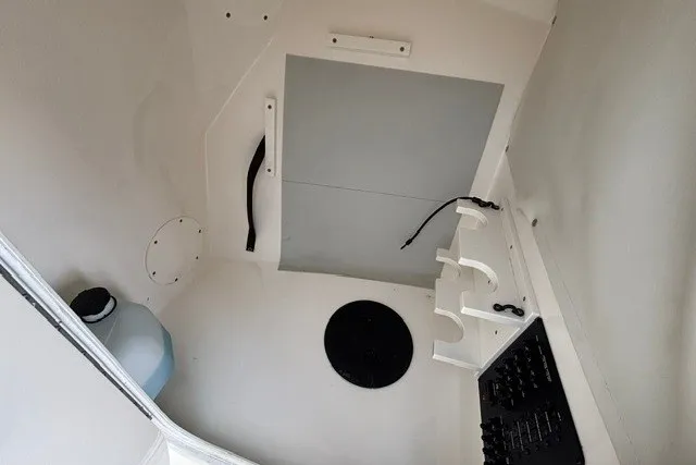 Slide: The Image of Interior view of a 2022 Cobia 280 Dual Console boat, featuring storage and utility compartments. - 23