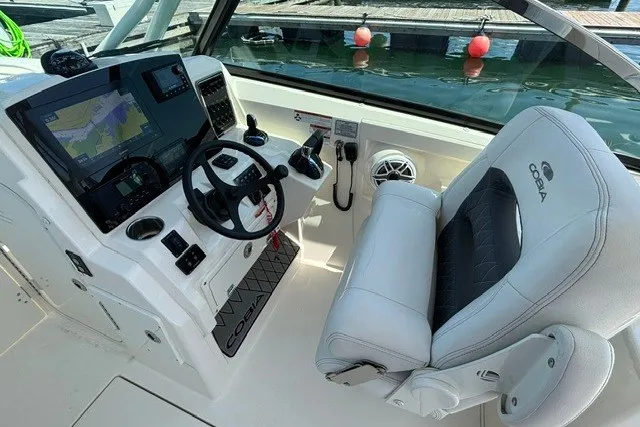 Slide: The Image of 2022 Cobia 280 Dual Console boat interior with steering wheel and navigation system. - 7