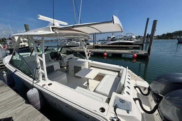 Slide: The Image of 2022 Cobia 280 Dual Console boat docked at marina under clear blue sky. - 18