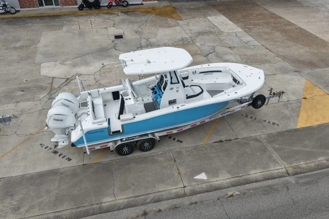 Slide: The Image of 2026 Tidewater 272 LXF boat on trailer, featuring dual Yamaha engines, parked on concrete. - 4