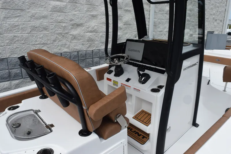 Slide: The Image of 2027 Sea Hunt Ultra 235SE boat interior with Garmin navigation and brown seating. - 7