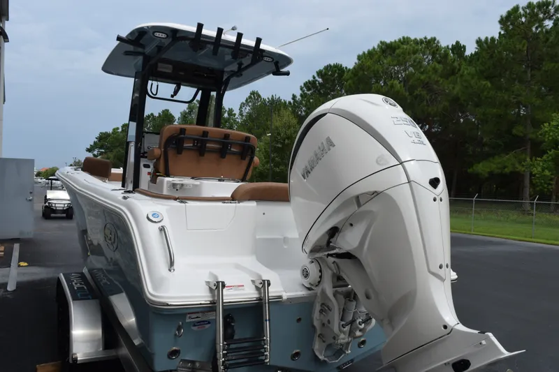 Slide: The Image of 2027 Sea Hunt Ultra 235SE boat with Yamaha V6 engine, parked outdoors. - 6