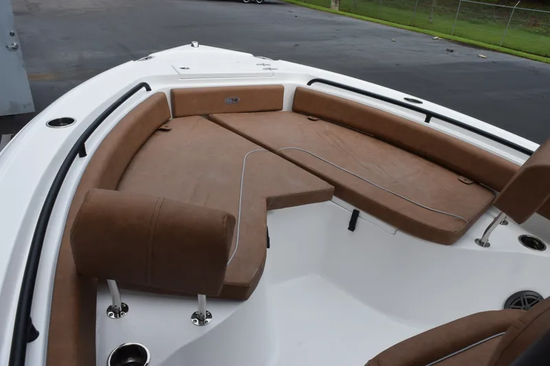 Slide: The Image of 2027 Sea Hunt Ultra 235SE boat interior with brown cushioned seating and cup holders. - 13