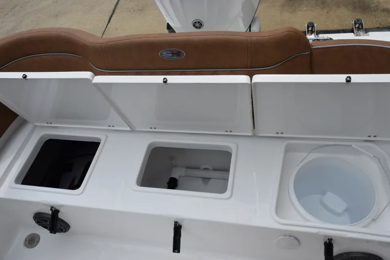 Slide: The Image of Open storage compartments on a 2027 Sea Hunt Ultra 235SE boat. - 21