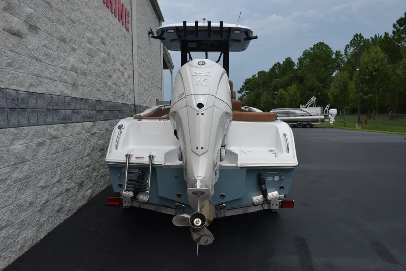 Slide: The Image of 2027 Sea Hunt Ultra 235SE boat with powerful outboard motor, parked outdoors. - 5