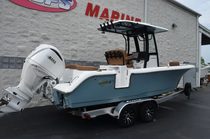Slide: The Image of 2027 Sea Hunt Ultra 235SE boat with Yamaha engine on trailer, parked outside marine shop. - 4