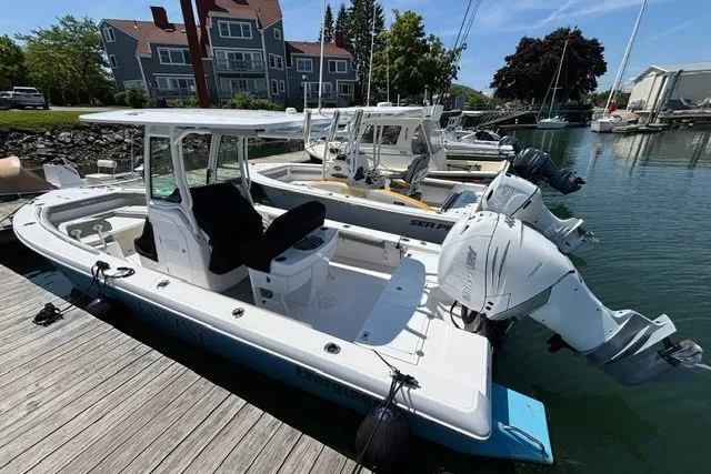 Slide: The Image of 2023 Everglades 253 Center Console boat docked in a marina, surrounded by other boats. - 2