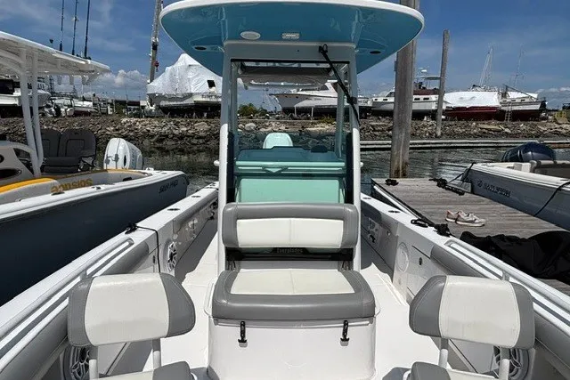 Slide: The Image of 2023 Everglades 253 Center Console boat docked at marina, showcasing seating and helm. - 6