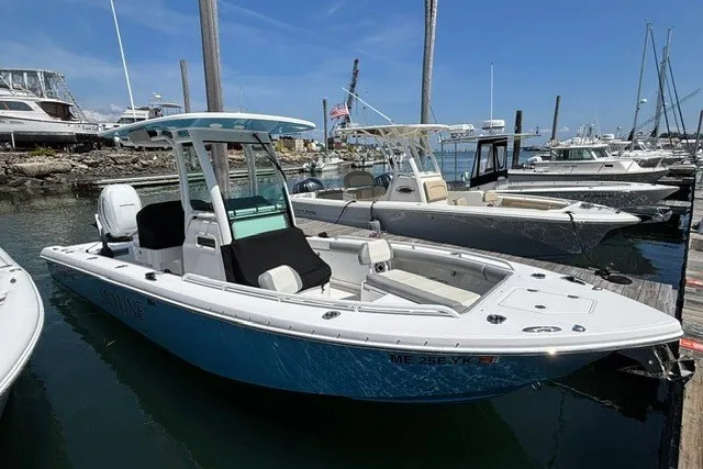 The Image of 2023 Everglades 253 Center Console boat docked in a marina under clear blue skies. - 0
