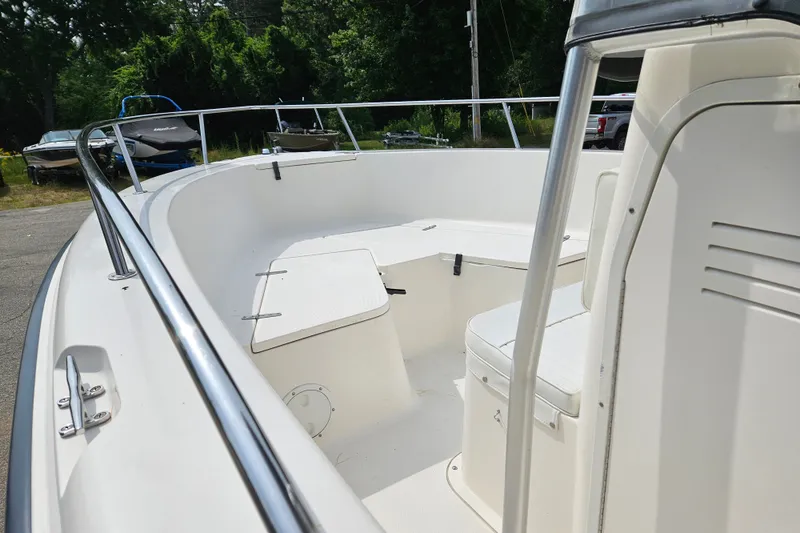 Slide: The Image of 2005 Sea Hunt Triton 232 boat interior with seating and railing, parked outdoors. - 11