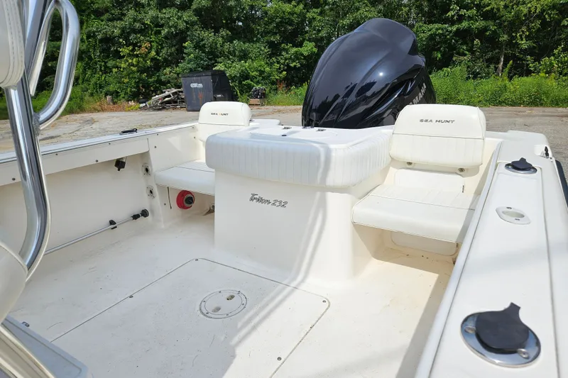 Slide: The Image of 2005 Sea Hunt Triton 232 boat interior with seating and Yamaha engine, surrounded by greenery. - 7