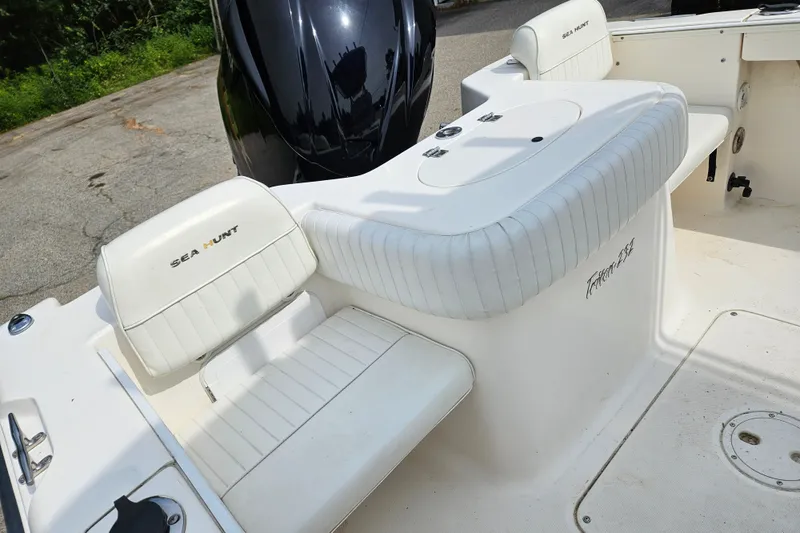 Slide: The Image of 2005 Sea Hunt Triton 232 boat interior with white seating and engine view. - 8