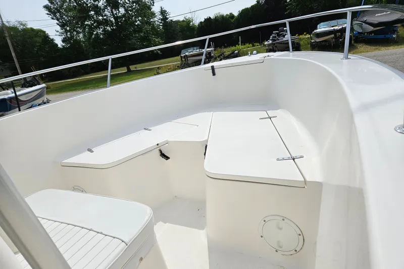 Slide: The Image of 2005 Sea Hunt Triton 232 boat interior with white seating and storage compartments. - 12