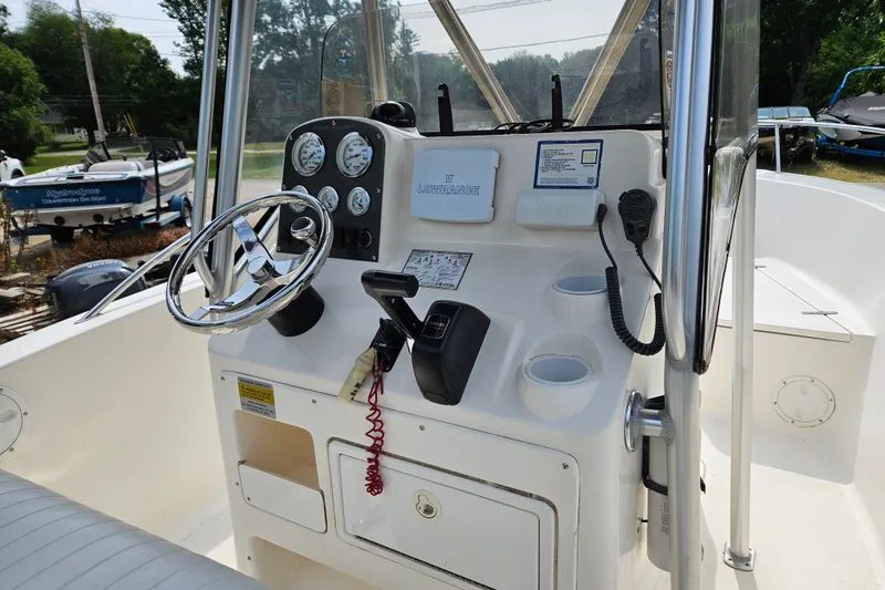 Slide: The Image of 2005 Sea Hunt Triton 232 boat console with steering wheel and gauges. - 13