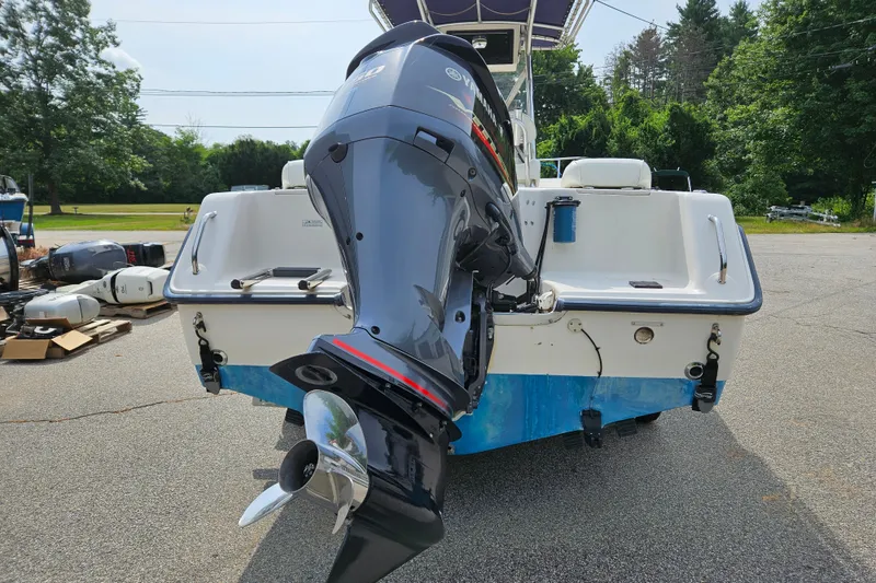 Slide: The Image of 2005 Sea Hunt Triton 232 boat with Yamaha outboard motor, parked outdoors. - 5