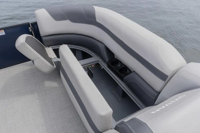 Slide: The Image of 2024 Sylvan L5 DLZ boat interior with gray seating and cup holders on the water. - 21