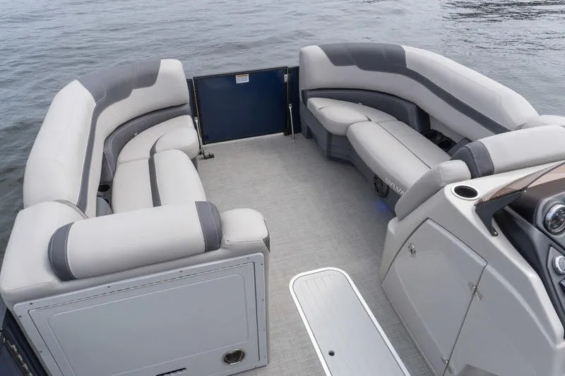 Slide: The Image of 2024 Sylvan L5 DLZ pontoon boat interior with spacious seating on calm water. - 19