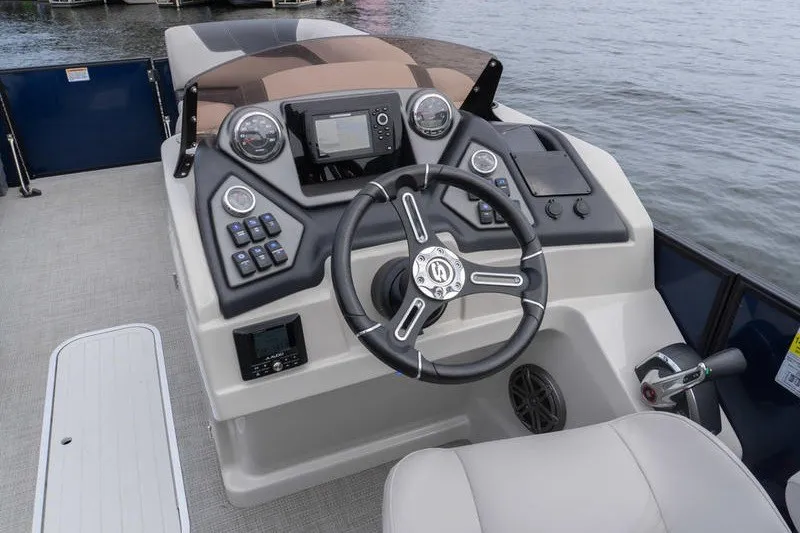 Slide: The Image of 2024 Sylvan L5 DLZ boat dashboard with steering wheel and control panel on water. - 9