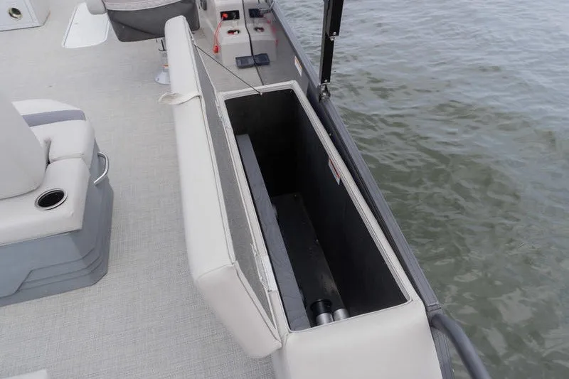 Slide: The Image of 2024 Sylvan L5 DLZ boat with open storage compartment on deck by the water. - 7