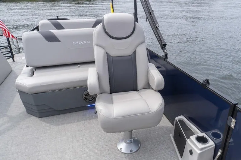 Slide: The Image of 2024 Sylvan L5 DLZ boat interior with plush seating on calm water. - 23