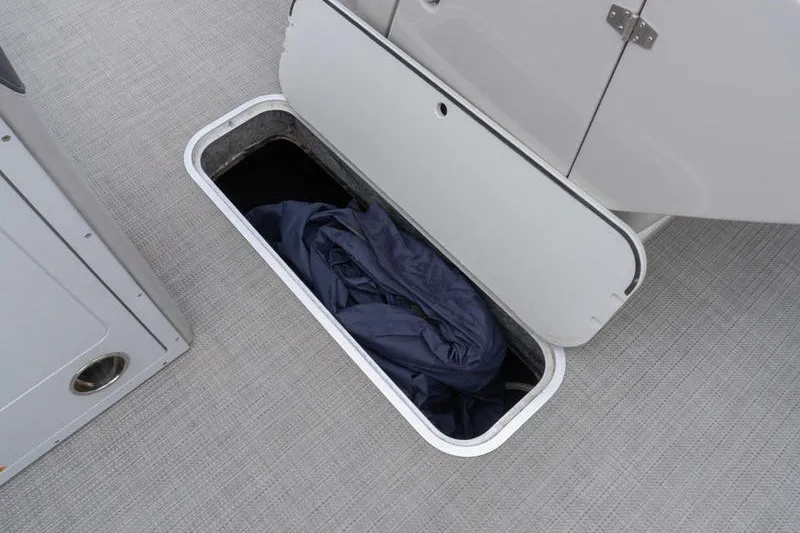 Slide: The Image of 2024 Sylvan L5 DLZ boat storage compartment with open hatch and fabric inside. - 17