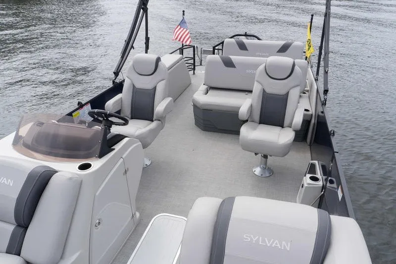 Slide: The Image of 2024 Sylvan L5 DLZ pontoon boat interior with plush seating and American flag. - 22