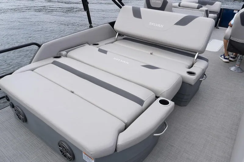 Slide: The Image of 2024 Sylvan L5 DLZ boat with luxurious seating and cup holders on a calm lake. - 5