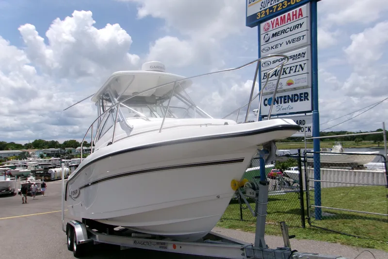 Slide: The Image of 2007 Century 2400 Walk-Around boat on trailer at dealership, cloudy sky background. - 2