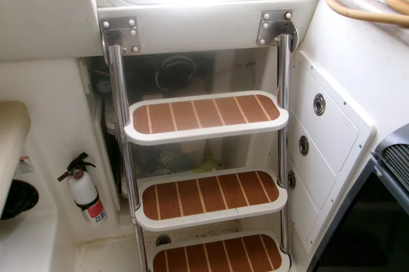 Slide: The Image of Staircase inside 2007 Century 2400 Walk-Around boat with wooden steps and metal rails. - 11