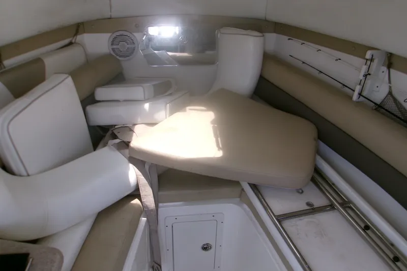 Slide: The Image of Interior of a 2007 Century 2400 Walk-Around boat with beige seating and storage compartments. - 8