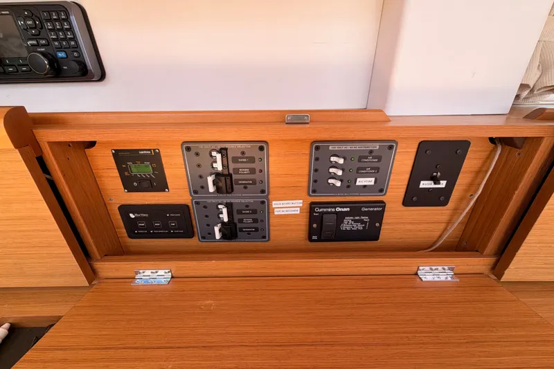 Slide: The Image of Control panel of a 2009 Jeanneau Sun Odyssey 45 DS sailboat, featuring various switches and displays. - 49