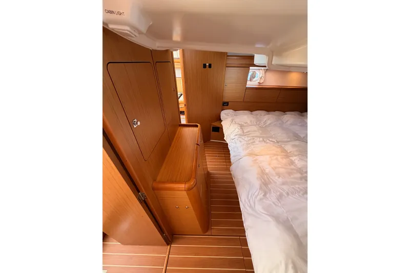 Slide: The Image of Interior cabin of 2009 Jeanneau Sun Odyssey 45 DS, featuring wood paneling and cozy bedding. - 86