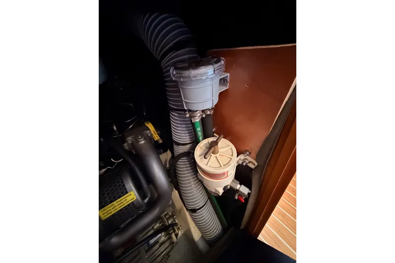 Slide: The Image of Engine compartment of 2009 Jeanneau Sun Odyssey 45 DS sailboat, showing hoses and filter system. - 95