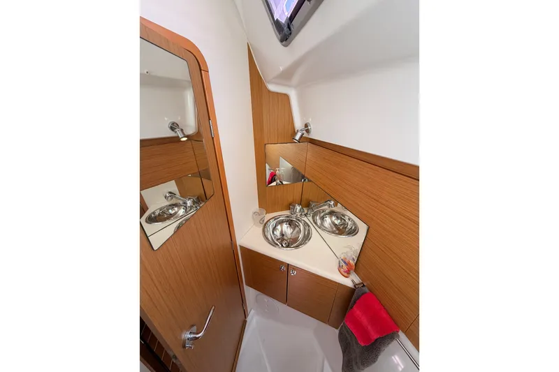 Slide: The Image of 2009 Jeanneau Sun Odyssey 45 DS bathroom with wooden cabinetry and stainless steel sink. - 82