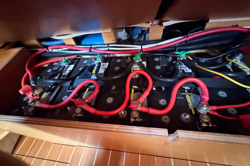 Slide: The Image of Battery compartment of a 2009 Jeanneau Sun Odyssey 45 DS sailboat, featuring red and black cables. - 92