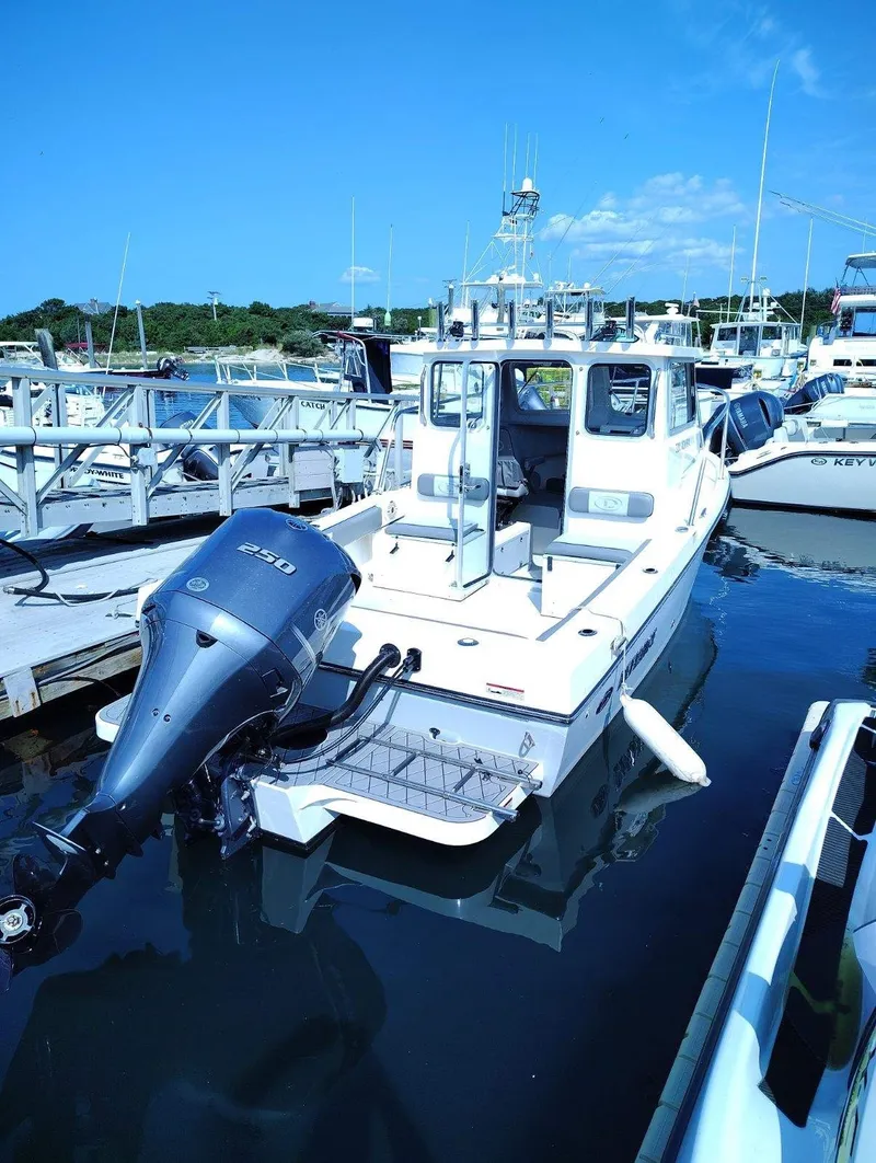 Slide: The Image of A 2024 Defiance Admiral 220 EX boat docked. It features an outboard motor. - 14