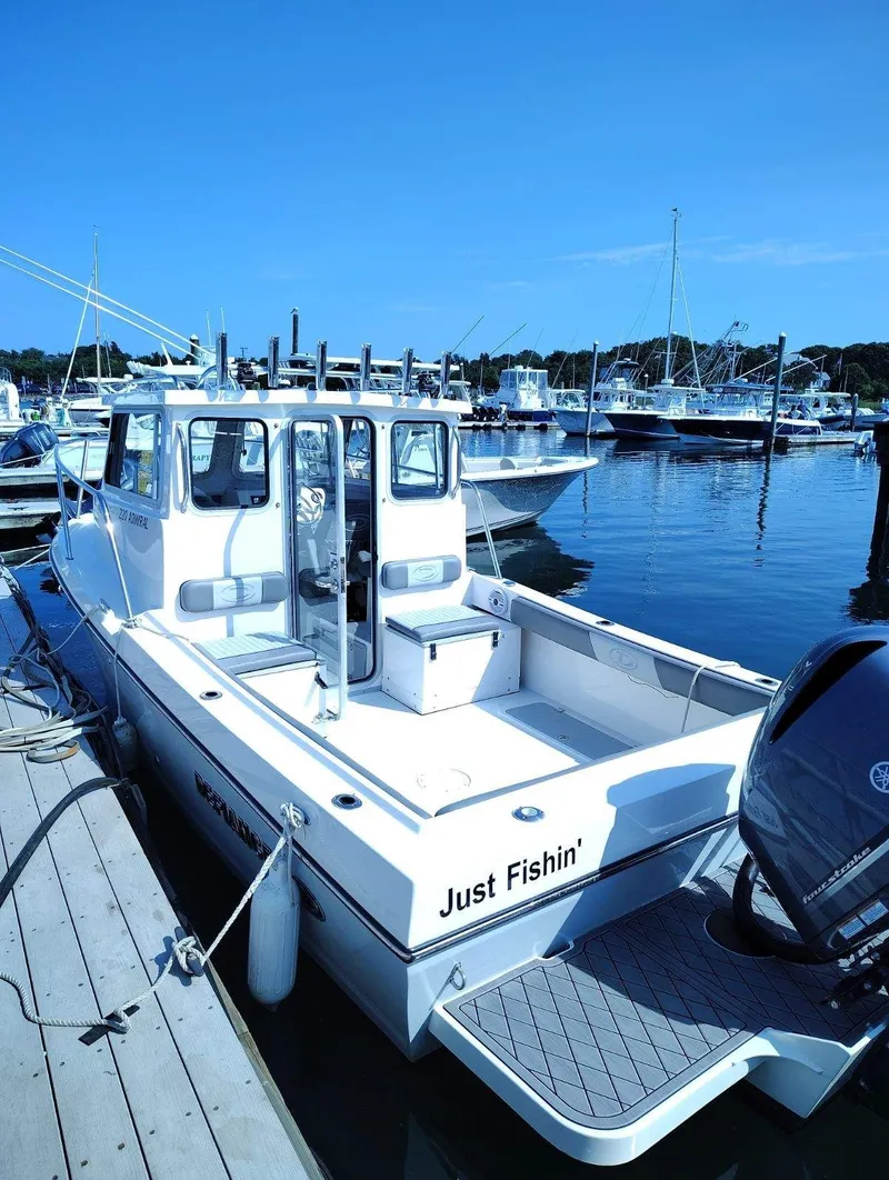 Slide: The Image of A white boat docked, named "Just Fishin'" on the back, with a spacious deck area. - 15
